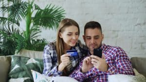 Image of couple holding credit card and phone